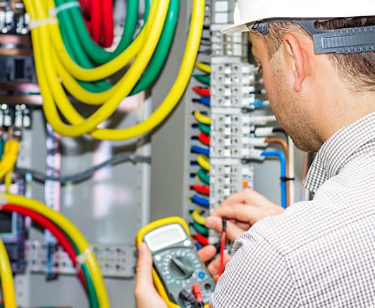 An electrician testing an electrical panel