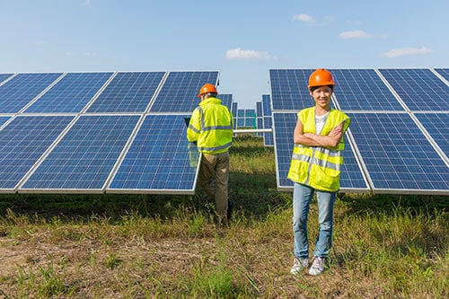 Two solar panel professionals working on a ground mount solar farm